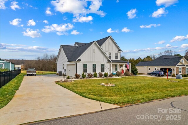 modern farmhouse style home with a front lawn, driveway, fence, cooling unit, and board and batten siding