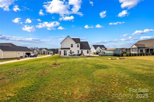 back of property featuring a residential view and a yard