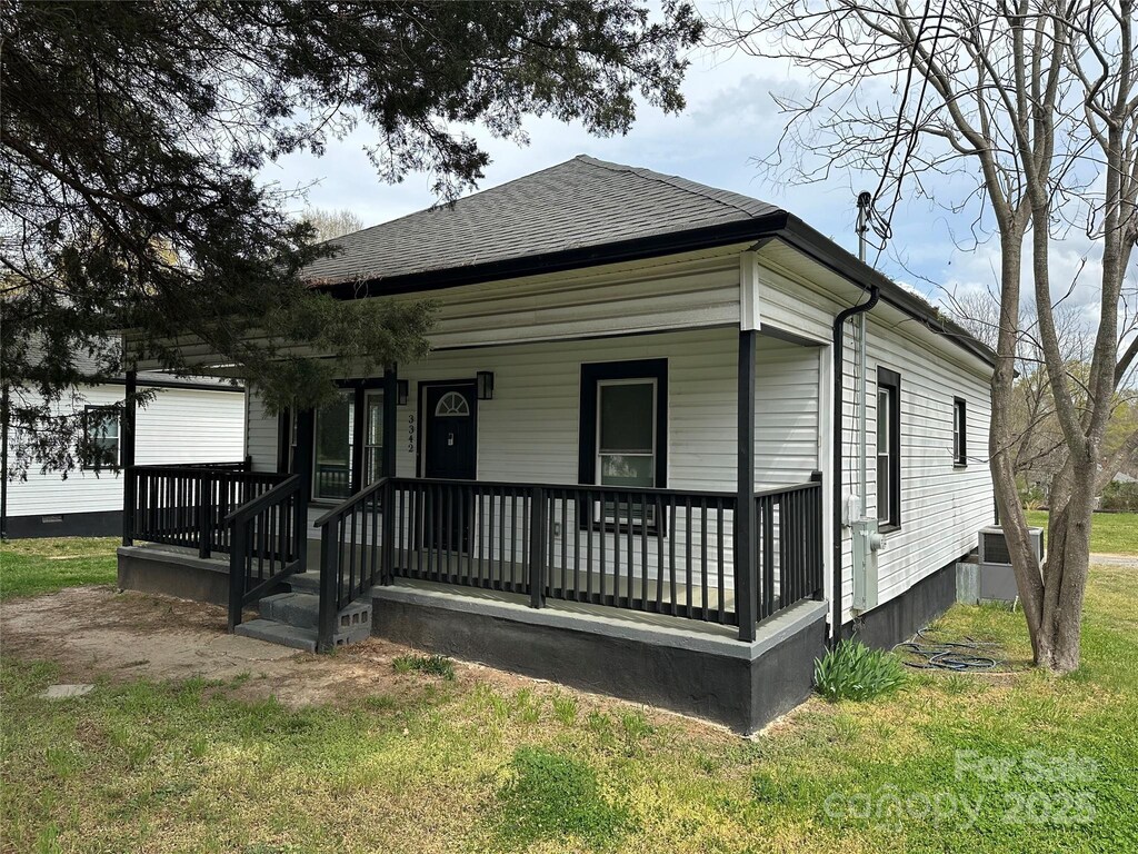 3342 York Hwy, Gastonia, NC 28052 - view of front facade with covered porch, a shingled roof, and a front lawn