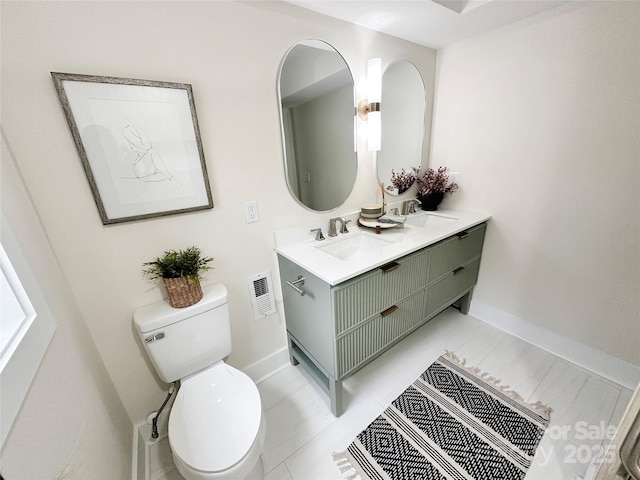 bathroom featuring visible vents, a sink, toilet, and double vanity