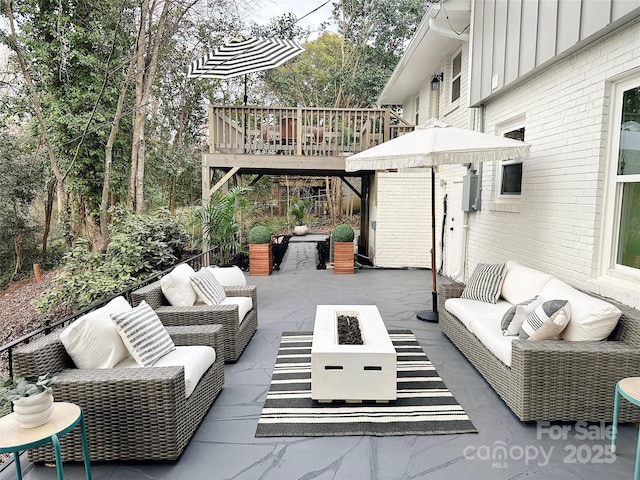 view of patio featuring an outdoor living space with a fire pit and a wooden deck