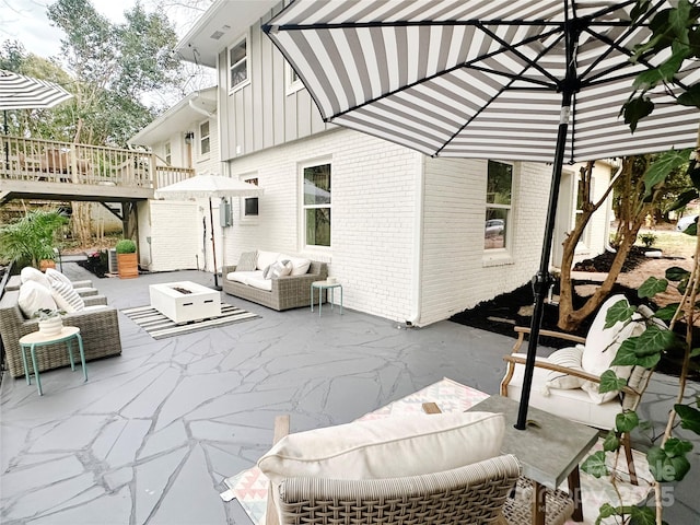 view of patio / terrace featuring a deck, stairway, and an outdoor living space with a fire pit