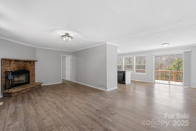 6 Clark Meadow Ln, Candler, NC 28715 - unfurnished living room with crown molding, baseboards, a fireplace, and wood finished floors