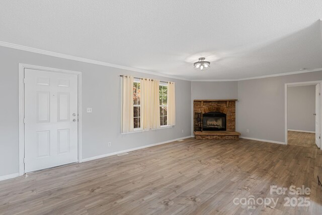 6 Clark Meadow Ln, Candler, NC 28715 - unfurnished living room featuring baseboards, a textured ceiling, ornamental molding, and wood finished floors