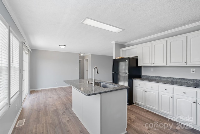 6 Clark Meadow Ln, Candler, NC 28715 - kitchen with a sink, white cabinetry, wood finished floors, dark stone countertops, and visible vents