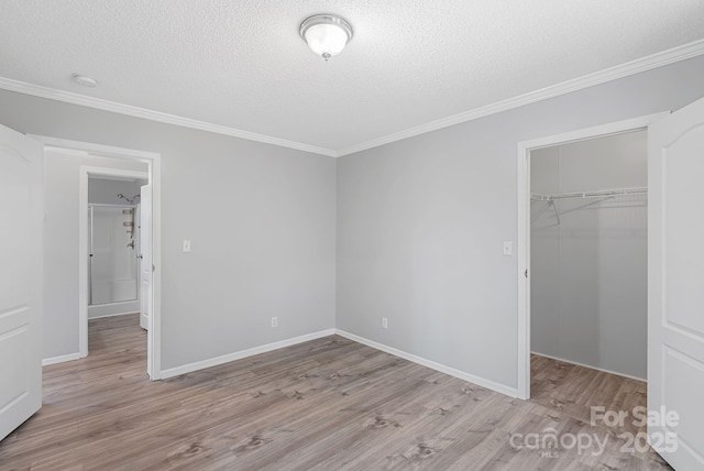 6 Clark Meadow Ln, Candler, NC 28715 - unfurnished bedroom with a closet, a textured ceiling, light wood-style flooring, crown molding, and a spacious closet