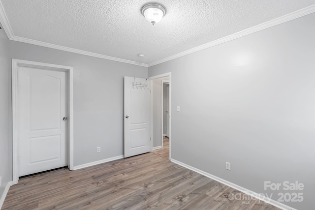 6 Clark Meadow Ln, Candler, NC 28715 - unfurnished bedroom featuring baseboards, crown molding, wood finished floors, and a textured ceiling
