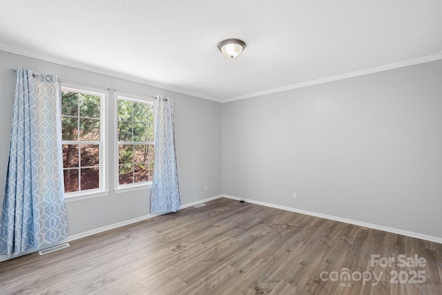 6 Clark Meadow Ln, Candler, NC 28715 - unfurnished room featuring a textured ceiling, visible vents, baseboards, ornamental molding, and wood finished floors