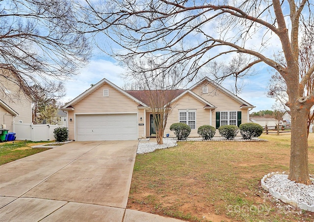 view of front of house with an attached garage, fence, a front lawn, and concrete driveway