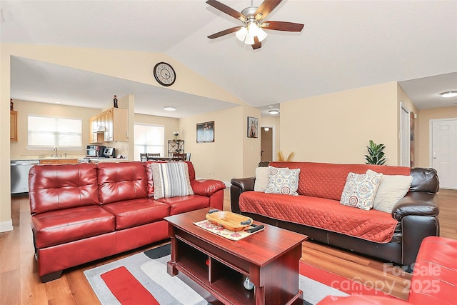 living room with lofted ceiling, a ceiling fan, and light wood-style floors