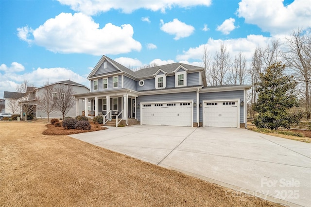 view of front of home with a garage, a porch, concrete driveway, and a front yard