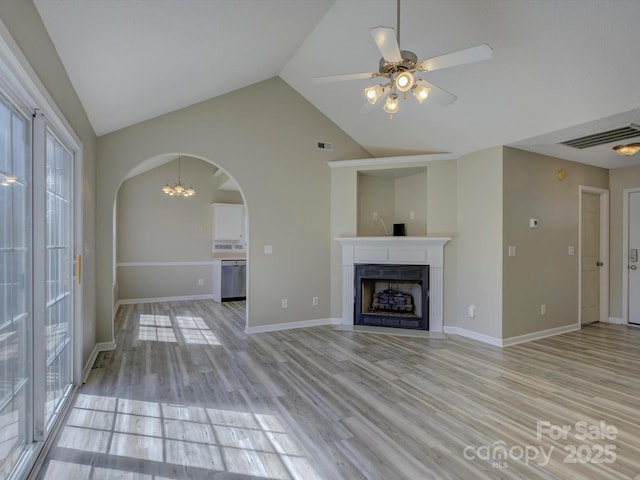 unfurnished living room with a fireplace with flush hearth, visible vents, arched walkways, and light wood-style flooring