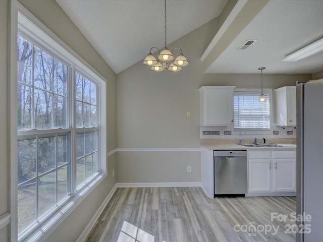 kitchen with light wood finished floors, light countertops, appliances with stainless steel finishes, and white cabinets