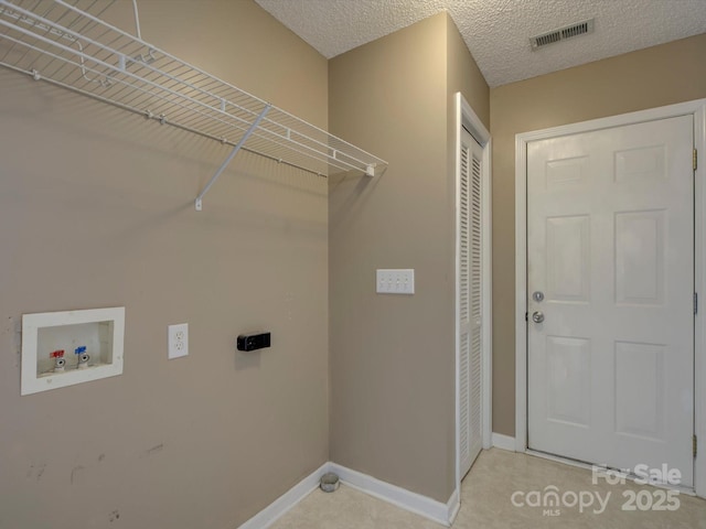 washroom with a textured ceiling, hookup for a washing machine, hookup for an electric dryer, laundry area, and visible vents