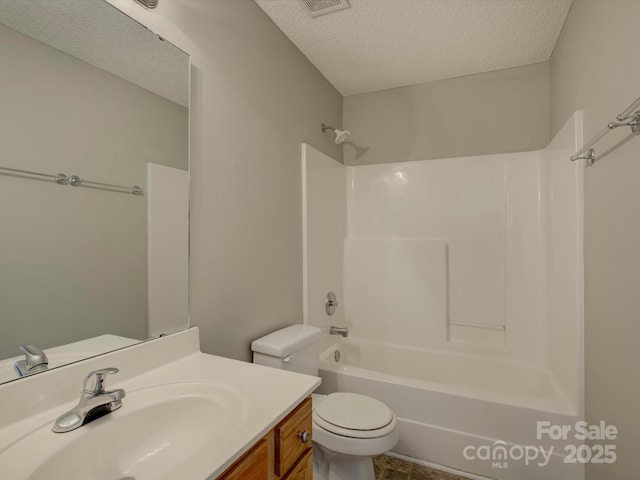 bathroom featuring bathtub / shower combination, a textured ceiling, toilet, and vanity