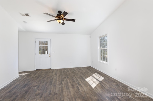 empty room featuring vaulted ceiling, wood finished floors, visible vents, and a healthy amount of sunlight