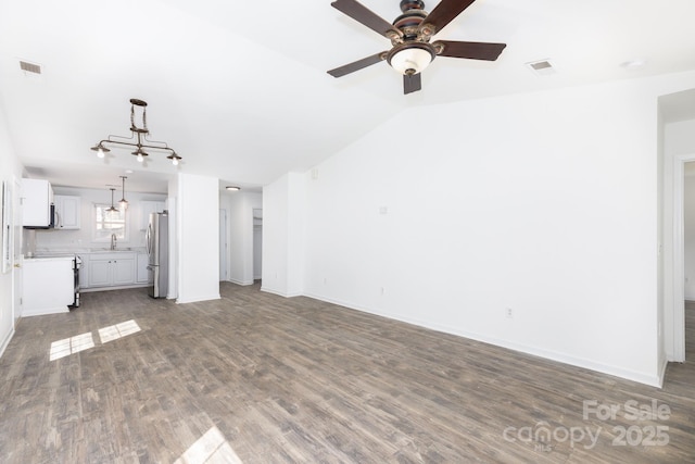 unfurnished living room featuring dark wood-style floors, visible vents, vaulted ceiling, and a sink