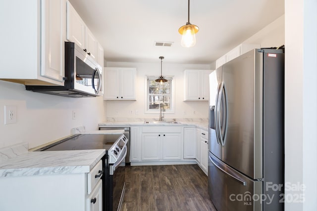 kitchen with a wealth of natural light, white cabinetry, stainless steel appliances, and a sink