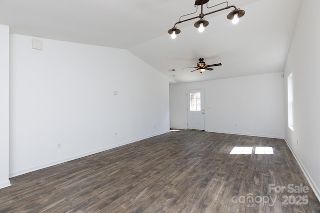 empty room with vaulted ceiling, ceiling fan, dark wood finished floors, and baseboards