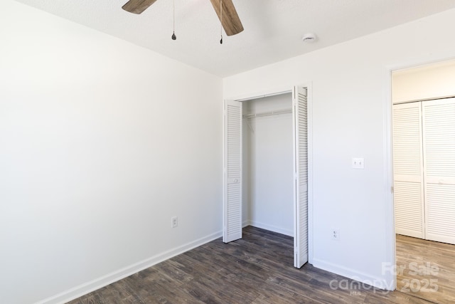 unfurnished bedroom with dark wood finished floors, a ceiling fan, and baseboards