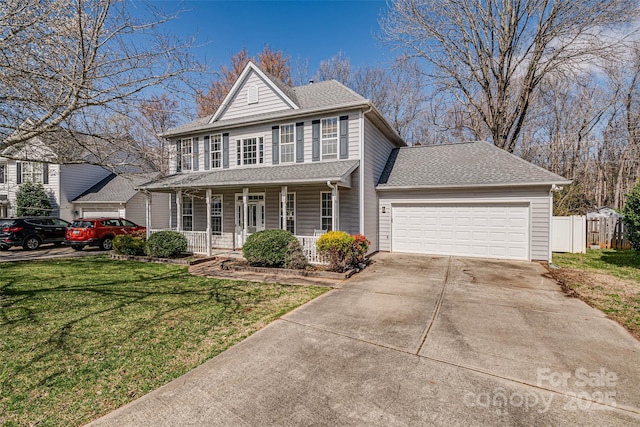 colonial-style house featuring a shingled roof, concrete driveway, an attached garage, fence, and a front lawn