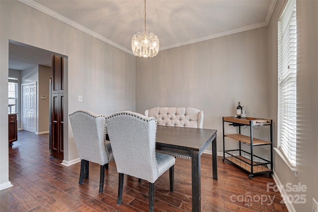 dining area featuring dark wood-style floors, baseboards, a chandelier, and crown molding