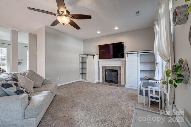 living area with recessed lighting, baseboards, carpet flooring, and a tiled fireplace