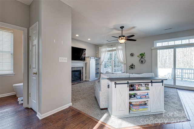 kitchen with a tile fireplace, visible vents, baseboards, white cabinets, and wood-type flooring