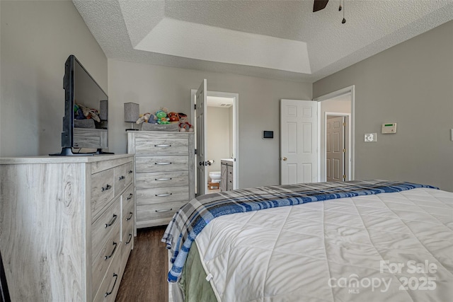 bedroom featuring dark wood-style flooring, ceiling fan, a textured ceiling, and ensuite bath