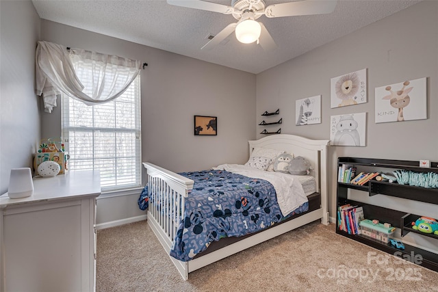 carpeted bedroom with a textured ceiling, a ceiling fan, and baseboards