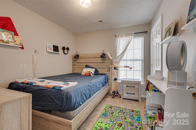 bedroom with visible vents, light carpet, and a textured ceiling