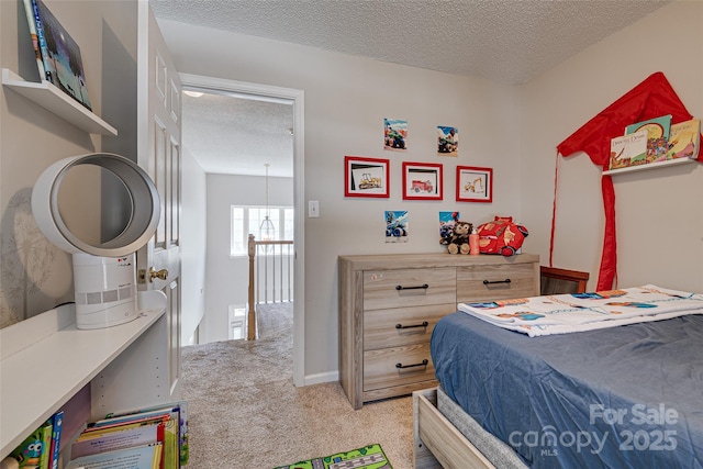 bedroom featuring light colored carpet and a textured ceiling