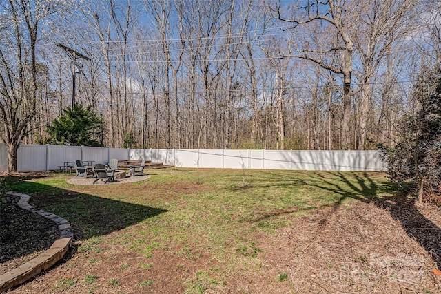 view of yard featuring a fenced backyard and a fire pit