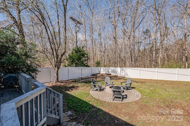 view of yard with a patio area, a fenced backyard, and a fire pit