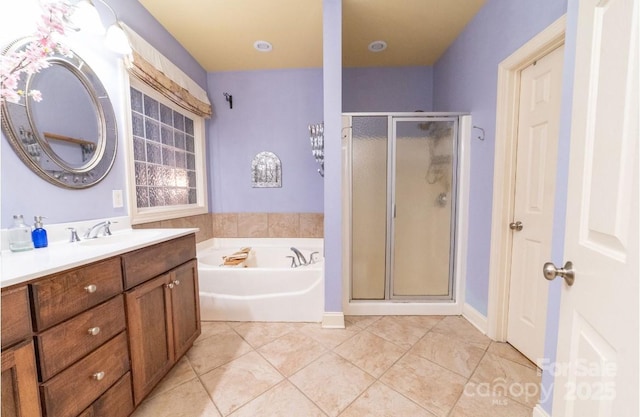 bathroom featuring tile patterned flooring, a garden tub, vanity, and a stall shower