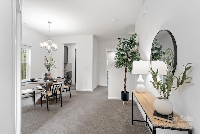 carpeted dining space featuring baseboards and a chandelier