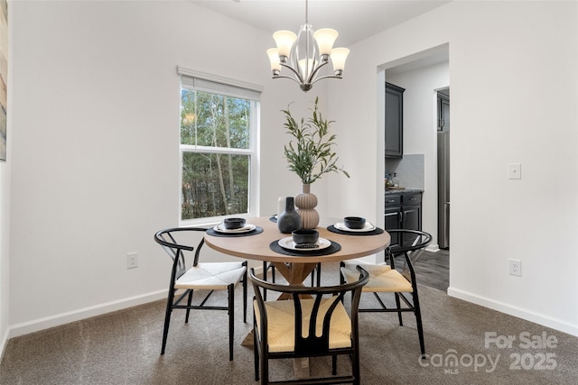 dining room with dark colored carpet, a notable chandelier, and baseboards