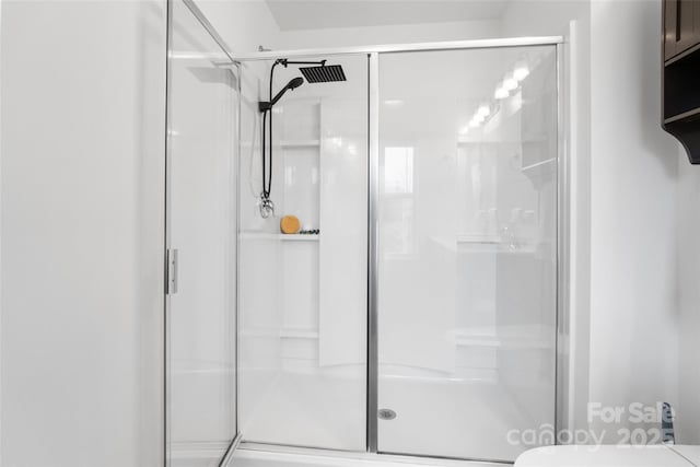 bathroom featuring a stall shower and toilet