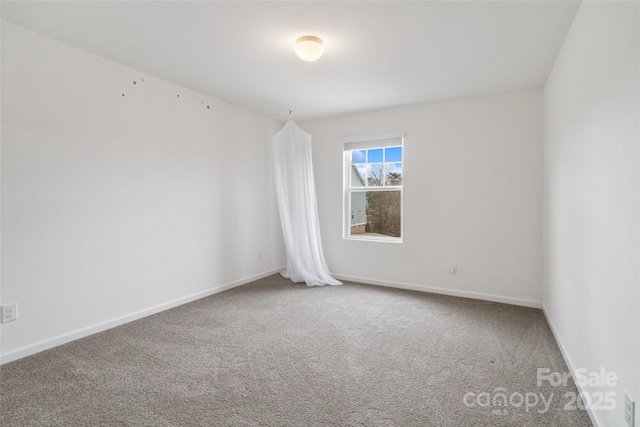 empty room featuring carpet and baseboards