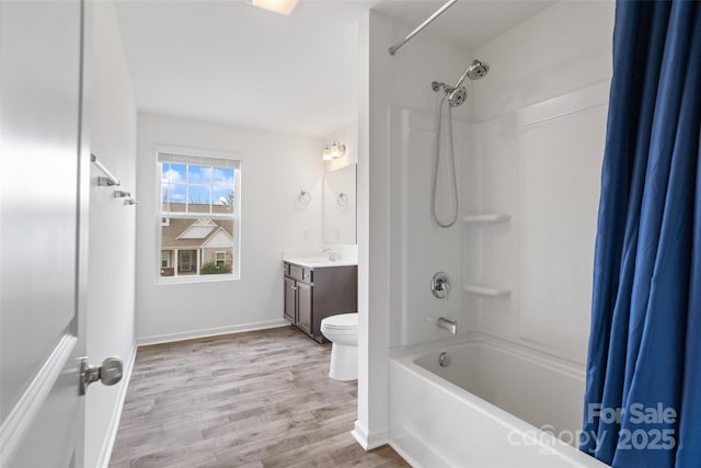 bathroom with toilet, shower / bath combo, vanity, wood finished floors, and baseboards