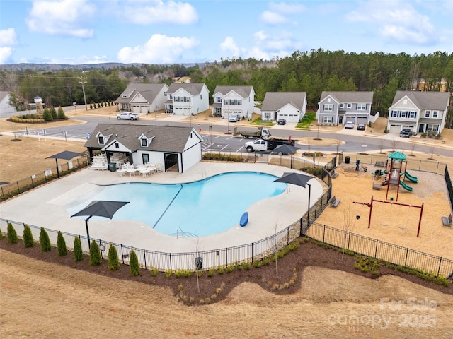 pool featuring playground community, a patio, fence, and a residential view