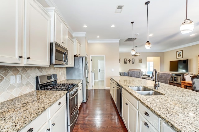 kitchen featuring visible vents, ornamental molding, stainless steel appliances, and a sink