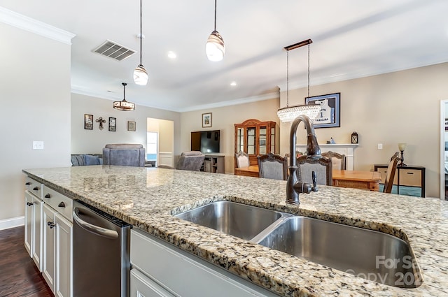 kitchen featuring visible vents, light stone countertops, crown molding, pendant lighting, and a sink