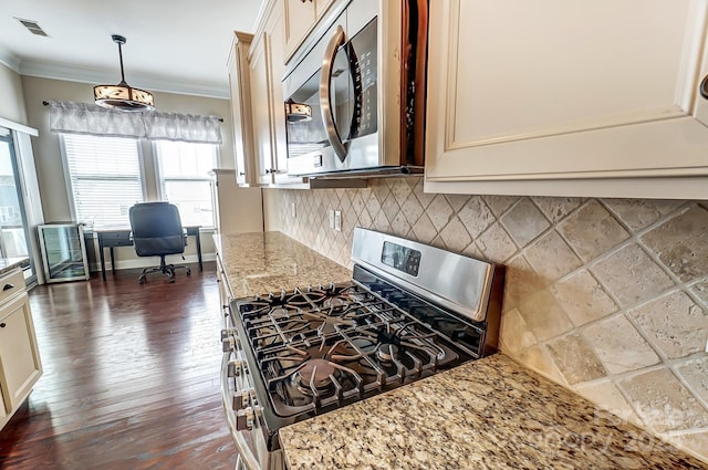 kitchen featuring visible vents, appliances with stainless steel finishes, light stone countertops, crown molding, and backsplash