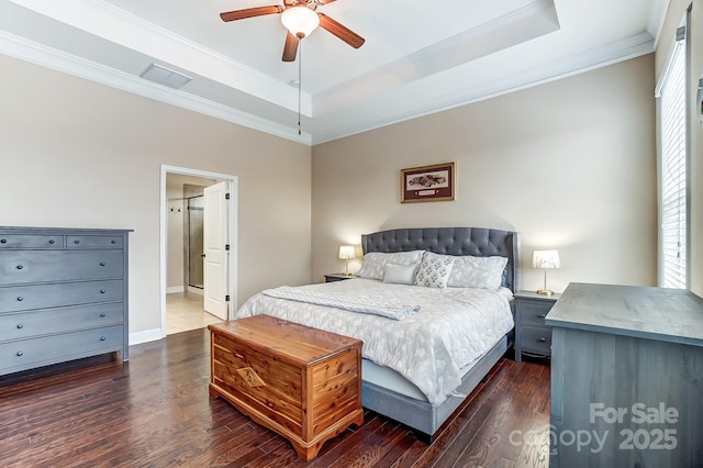 bedroom with ornamental molding, a tray ceiling, and dark wood-style flooring