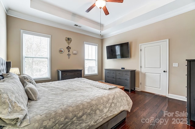 bedroom with visible vents, baseboards, ornamental molding, dark wood-style floors, and a raised ceiling