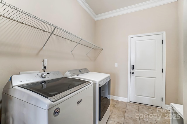 laundry room featuring crown molding, light tile patterned flooring, separate washer and dryer, laundry area, and baseboards