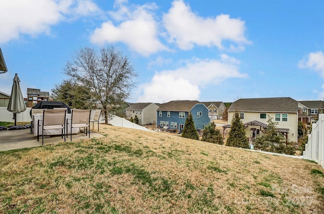 view of yard featuring a patio area, fence, and a residential view