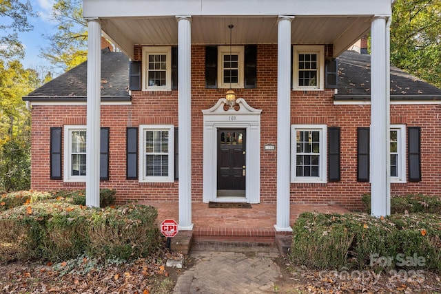 neoclassical home featuring brick siding