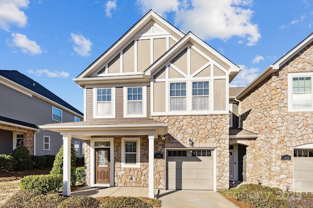 view of front of home with driveway, stone siding, and an attached garage